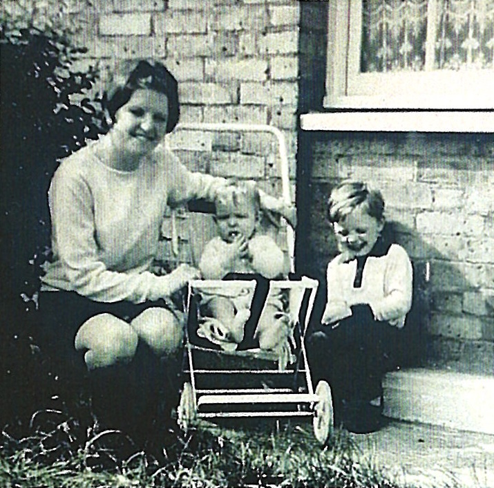 Black and white photo of Nan and two little boys, my dad and my uncle, who is in a buggy.